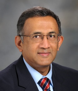 A person wearing glasses and a suitDescription automatically generated with medium confidence